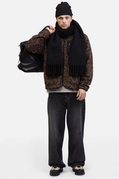 Jean délavé gris foncé de REDEFINED REBEL, porté avec un pull en teddy marron, un chapeau noir et une écharpe.