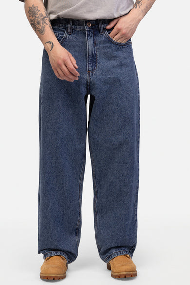Jean en denim bleu large de REDEFINED REBEL, avec une application de cactus sur la poche arrière.