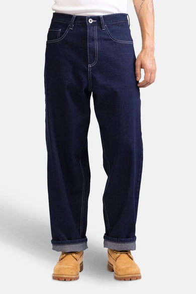 Jean délavé bleu marine large de denim de REDEFINED REBEL, avec des surpiqures blanches et des jambes retroussées.