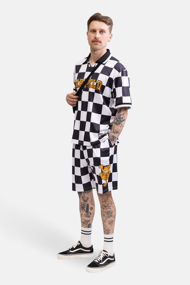 Man in een geruite Garfield outfit met tattoos.