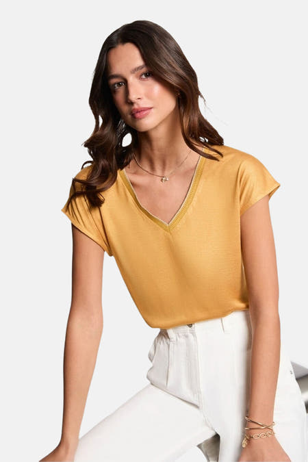 T-shirt jaune à manches courtes de Morgan De Toi, avec une coupe décontractée et porté avec un pantalon blanc et des baskets.