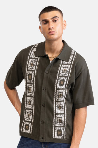 Chemise verte à manches courtes de REDEFINED REBEL, avec des lignes verticales à pois dans le dos, portée par un homme en jean.