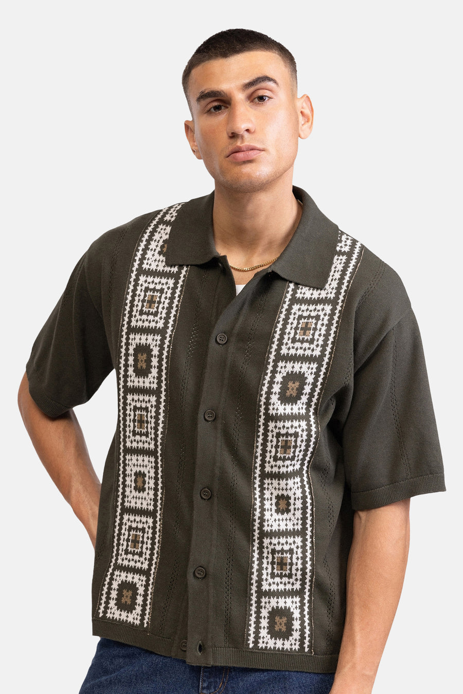 Chemise verte à manches courtes de REDEFINED REBEL, avec des lignes verticales à pois dans le dos, portée par un homme en jean.