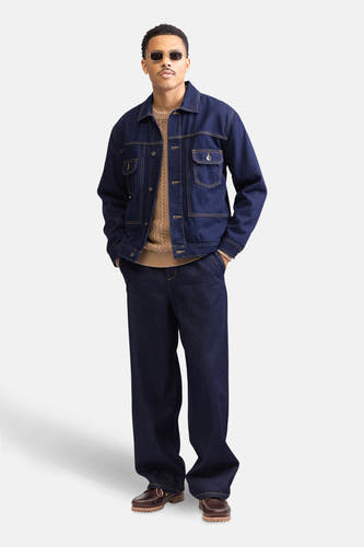 Pull beige avec col rond de REDEFINED REBEL, porté sous un blouson de denim bleu marine et des jeans larges.