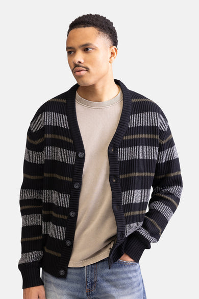 Gilet noir de REDEFINED REBEL avec un motif à rayures, porté sur un T-shirt simple et des jeans.