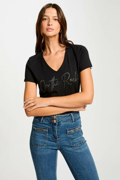 T-shirt noir à manches courtes de Morgan De Toi, porté avec des jeans bleus à poches dépassantes et des baskets noires.