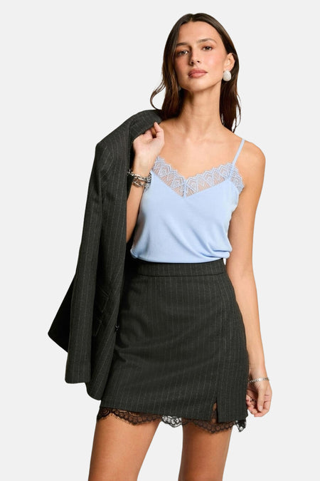 Short skirt in gray from Morgan De Toi, with a chalk stripe and hemmed edges, worn with a blue top and blazer.