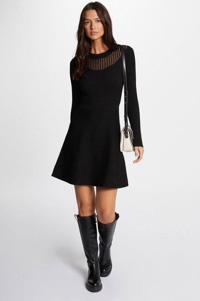 Robe noire à longues manches de Morgan De Toi, avec une encolure transparente et des bottes noires.