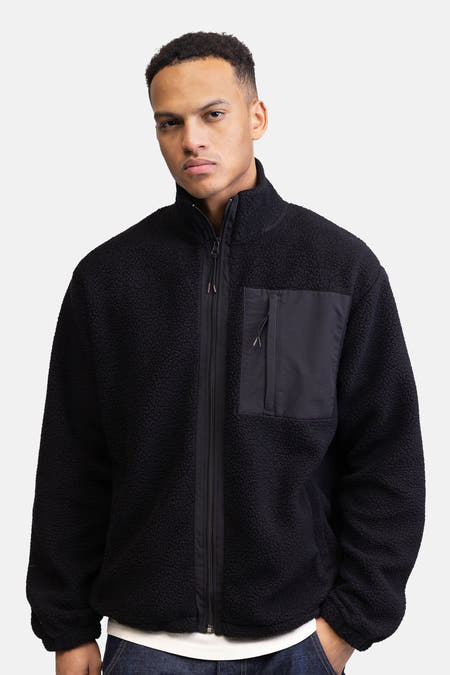 Fleece noir de REDEFINED REBEL, avec un col montant, un détail de poche et une fermeture éclair à l'avant.