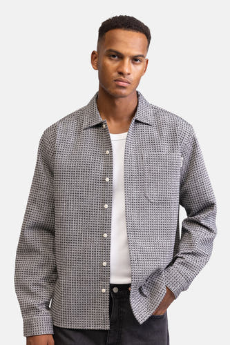 Chemise grise à manches longues de REDEFINED REBEL, avec un motif subtil et portée sur un T-shirt blanc.