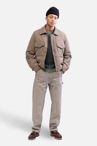 Manteau court beige de REDEFINED REBEL, porté avec un pull vert et des chaussures marron.