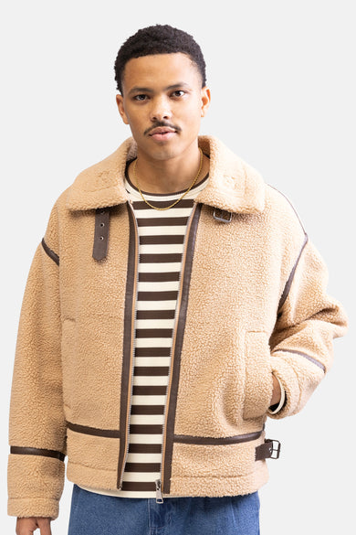 Man met bruine jas en gestreepte trui.