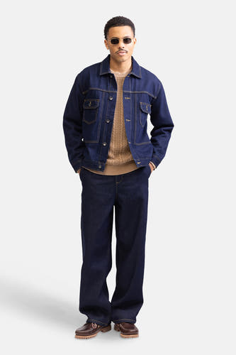 Manteau de denim bleu marine de REDEFINED REBEL, porté avec un pull marron et des jeans bleu marine.