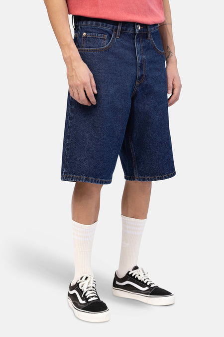 Short en jean en denim bleu marine de REDEFINED REBEL avec marguerite brodée sur la poche arrière et patch en cuir.