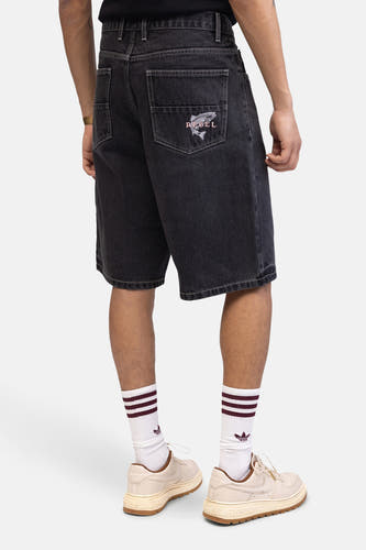 Jean court en denim gris anthracite de REDEFINED REBEL avec des détails brodés sur la poche arrière, associé à des chaussettes blanches et des baskets brunes.
