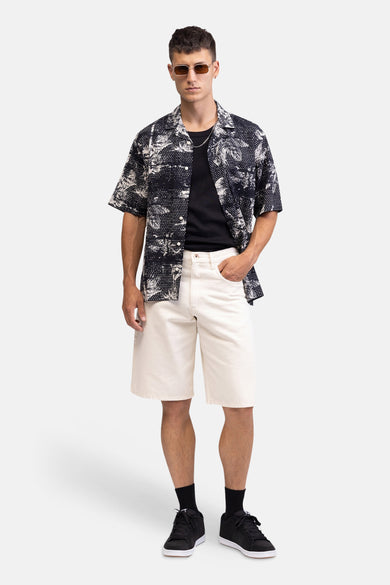 Short en jean écru de REDEFINED REBEL avec tournesol brodé sur la poche arrière droite et étiquette en cuir noir sur la ceinture, vue de dos.