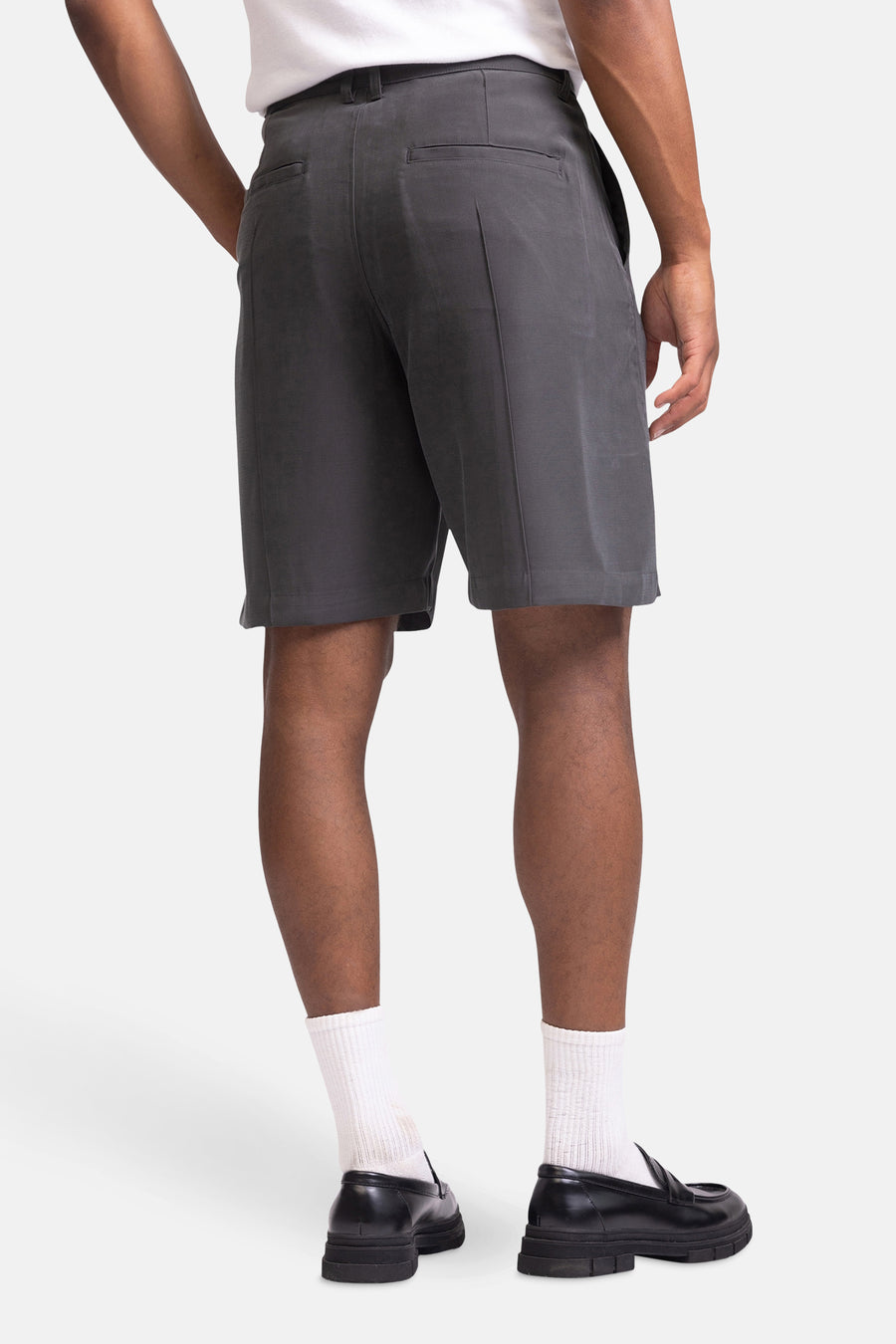 Short gris de REDEFINED REBEL, avec des poches arrière, combiné à des chaussettes blanches et des chaussures noires.