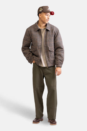 Pantalon vert de REDEFINED REBEL, associé à une veste brune à carreaux, un T-shirt et des chaussures brunes.