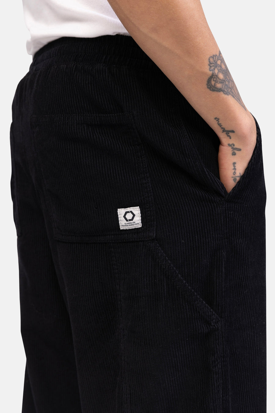 Pantalon noir de REDEFINED REBEL, fabriqué en coton, avec poche et détail d'étiquette de marque.