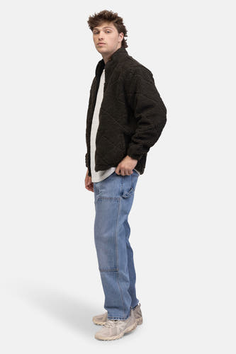Jean décontracté de denim bleu clair de REDEFINED REBEL, avec des poches genouxles et porté avec un gilet marron foncé.