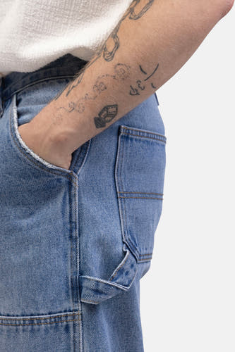 Jean denim bleu clair délavé de REDEFINED REBEL, avec poche et tatouages sur l'bras.