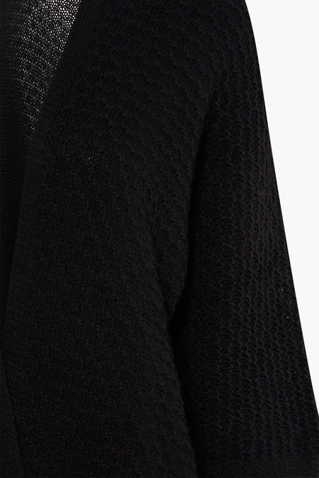 Cardigan noir de Terra di Siena, avec une texture tricotée et des manches longues, version cropped.
