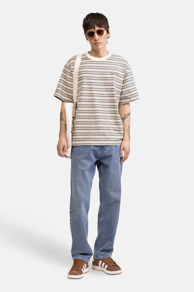 T-shirt multicolore de REDEFINED REBEL, avec des rayures horizontales et porté avec un jean et des baskets en daim.