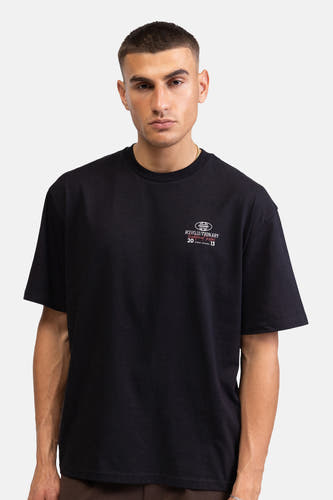 T-shirt noir à manches courtes de REDEFINED REBEL, avec imprimé blanc 'REVOLUTIONARY' (R inversé) et 'REDEFINED REBEL' au dos.