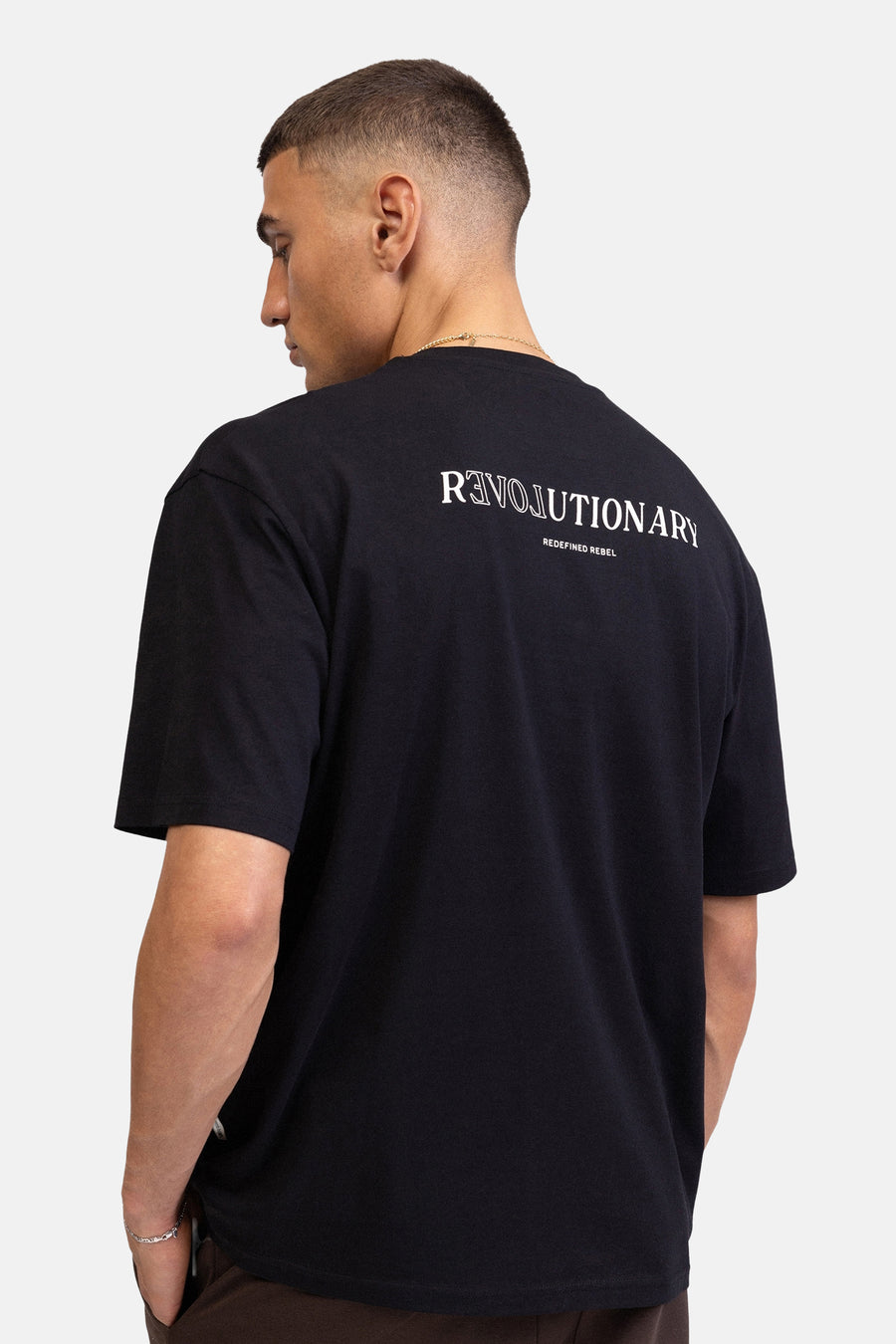 Zwart T-shirt met korte mouwen van REDEFINED REBEL, met witte 'REVOLUTIONARY' (spiegelende R) en 'REDEFINED REBEL' print op de rug.