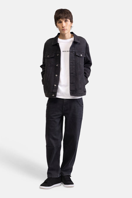 T-shirt blanc de REDEFINED REBEL avec 'HOUSE RULE' sur la poitrine, porté par un mannequin avec une veste en jean noir, un jean noir et des baskets noires.