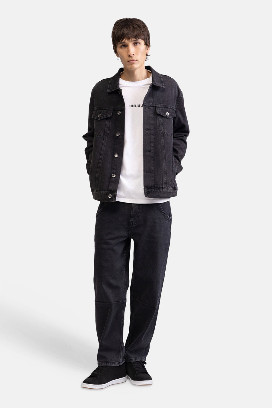 T-shirt blanc de REDEFINED REBEL avec 'HOUSE RULE' sur la poitrine, porté par un mannequin avec une veste en jean noir, un jean noir et des baskets noires.