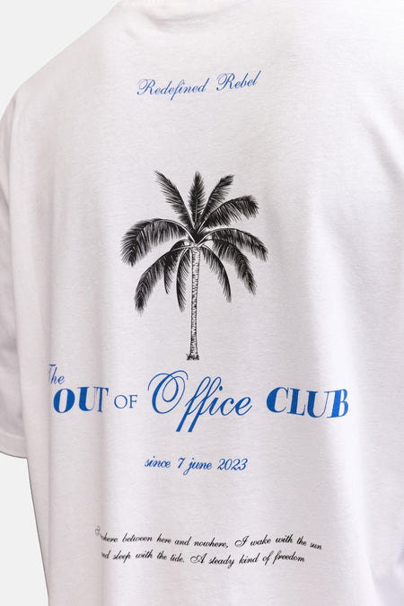 T-shirt blanc de REDEFINED REBEL avec texte bleu 'Redefined Rebel', un palmier et 'OUT of Office CLUB' dans le dos.