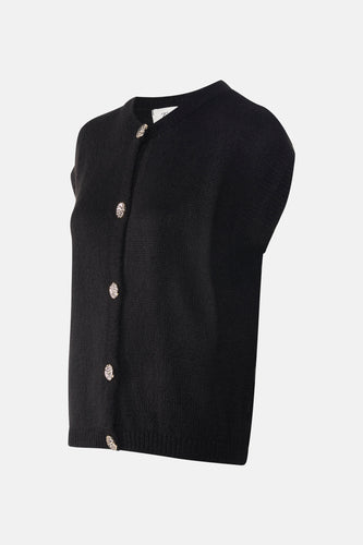 Veste noire de Terra di Siena avec des boutons décoratifs, photographiée d'un angle oblique.