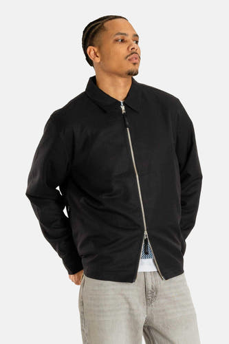 Manteau court noir de Woodbird, avec des manches longues et une fermeture éclair argentée.