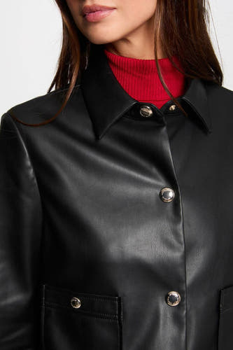 Manteau court noir de Morgan De Toi avec des boutons argentés, porté sur un gilet rouge.