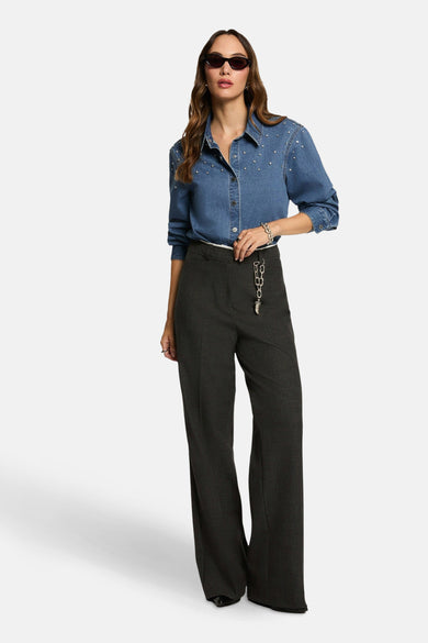 Chemise en denim bleu à longues manches de Morgan De Toi, avec des strass argentés et portée avec un pantalon gris foncé.
