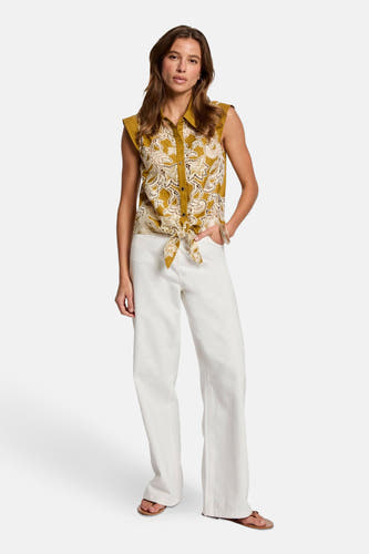 Blouse sans manches Morgan De Toi avec un motif de dentelle décoratif et un détail de nœud à l'avant, associée à une jupe blanche.