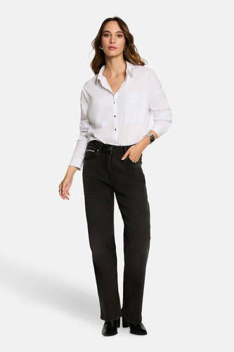 Chemise blanche à manches longues de Morgan De Toi, avec des détails décoratifs sur la patte d'épaule et portée avec des jeans noirs.