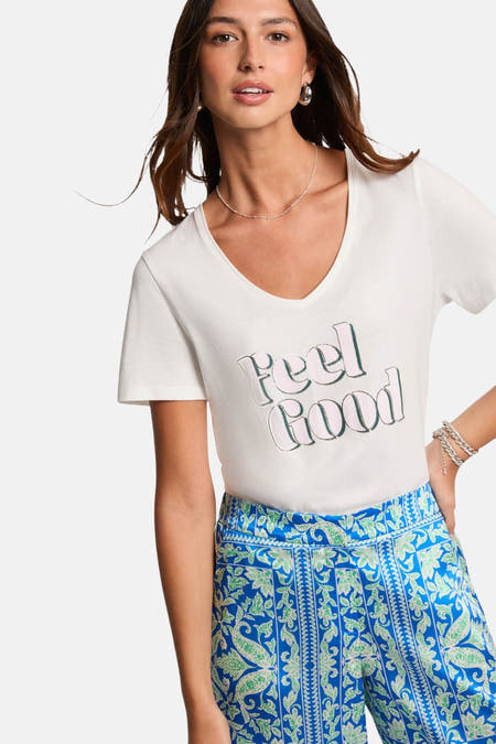 T-shirt blanc à manches courtes de Morgan De Toi, avec le texte "Feel Good" et un pantalon bleu à motif paisley.