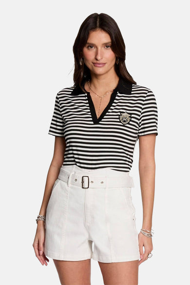 Polo rayé noir et blanc à manches courtes de Morgan De Toi, avec une élégante broderie et associé à un short blanc.
