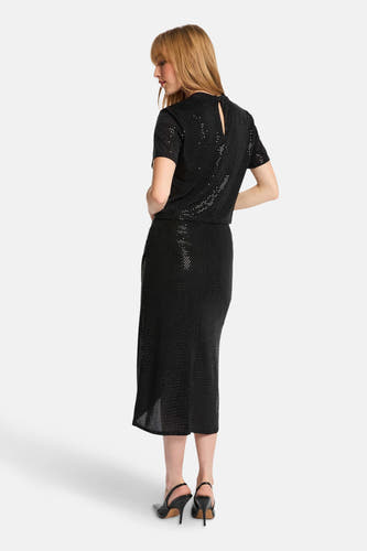 Robe noire de Morgan De Toi, avec motif pailleté, longueur midi et talons hauts.
