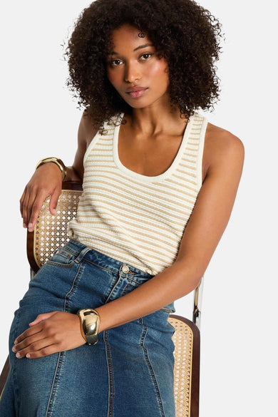 Top écru sans manches de Morgan De Toi, avec des rayures dorées et une jupe en denim avec des bracelets dorés.