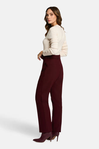Bordeaux broek van Morgan de Toi, met hoge taille, rechte pijpen en gecombineerd met gebreide trui en bordeauxkleurige laarsjes.
