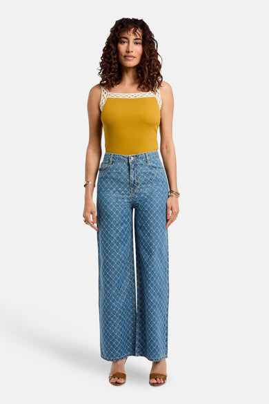 Jean bleu de denim de Morgan De Toi, avec un motif de fenêtre frappant et une jambe large, associé à une chemise marron.