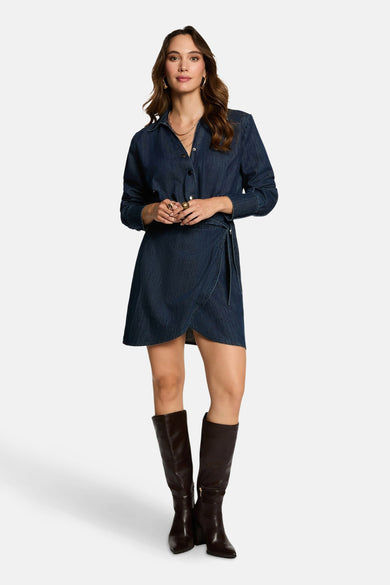 Manteau de denim bleu marine à longues manches de Morgan De Toi, avec un modèle plissé et des bottes brunes.