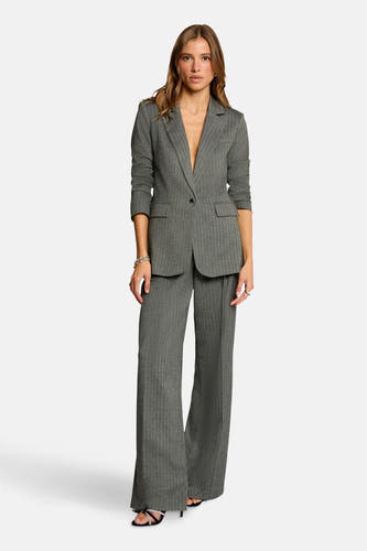 Blazer gris de Morgan De Toi, avec une subtile rayure, porté avec un pantalon large coordonné et des sandales frappantes.