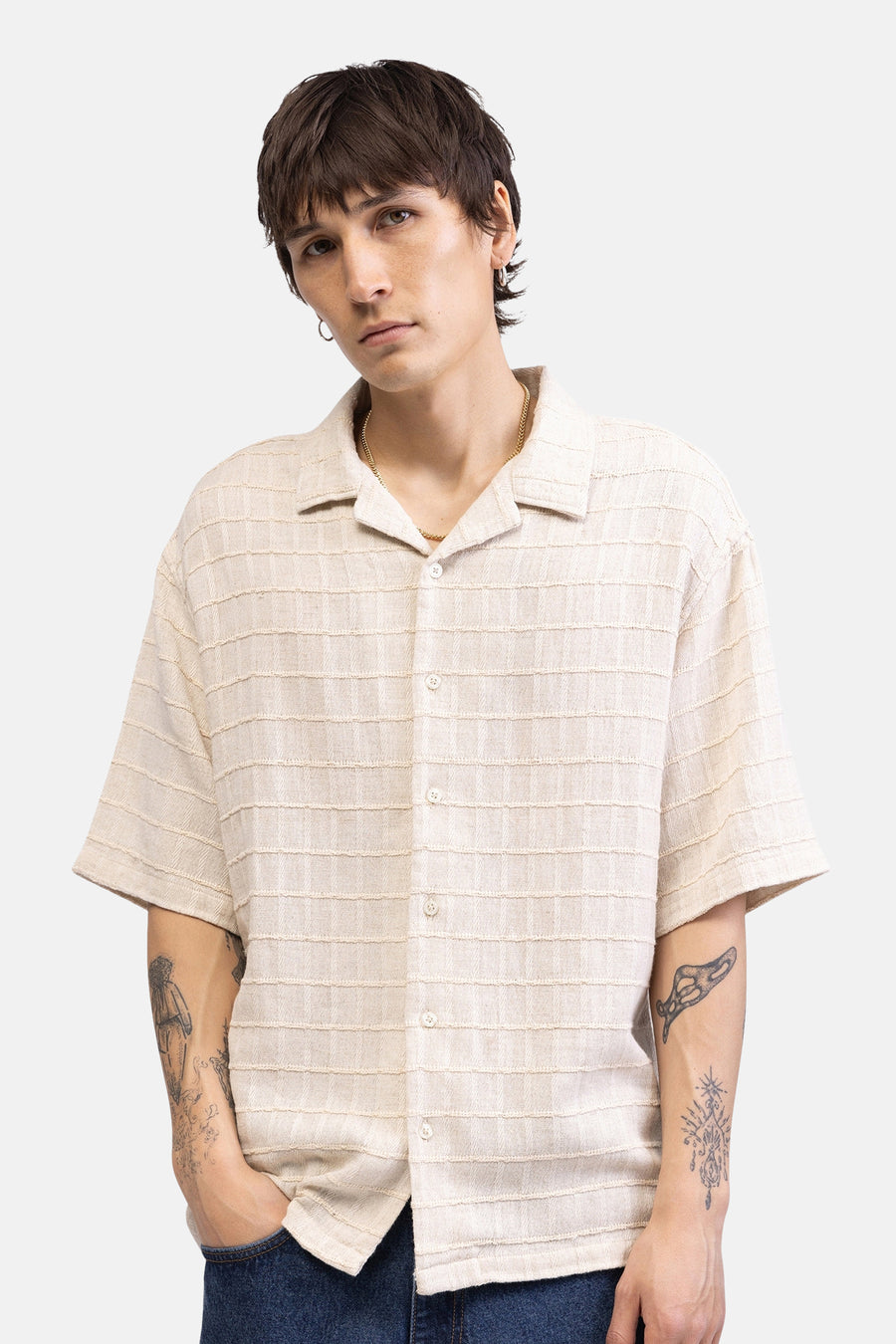 Chemise beige à manches courtes de REDEFINED REBEL, avec des rayures horizontales texturées, visible au dos d'un mannequin tatoué.