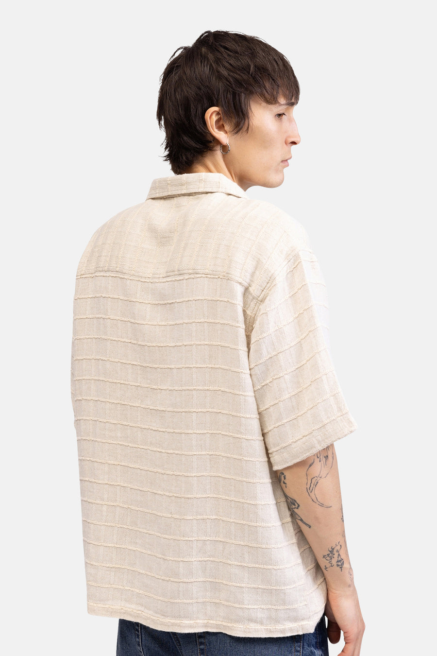 Beige overhemd met korte mouwen van REDEFINED REBEL, met gestructureerde horizontale strepen, zichtbaar op de achterkant van een model met tatoeages.