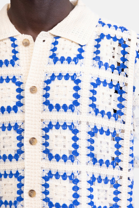 Pull en crochet blanc et bleu de REDEFINED REBEL avec motif carré et fermeture à boutons.