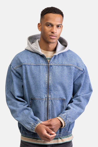 Veste en jean REDEFINED REBEL en denim bleu moyen, avec une capuche grise et une fermeture éclair sur le devant.